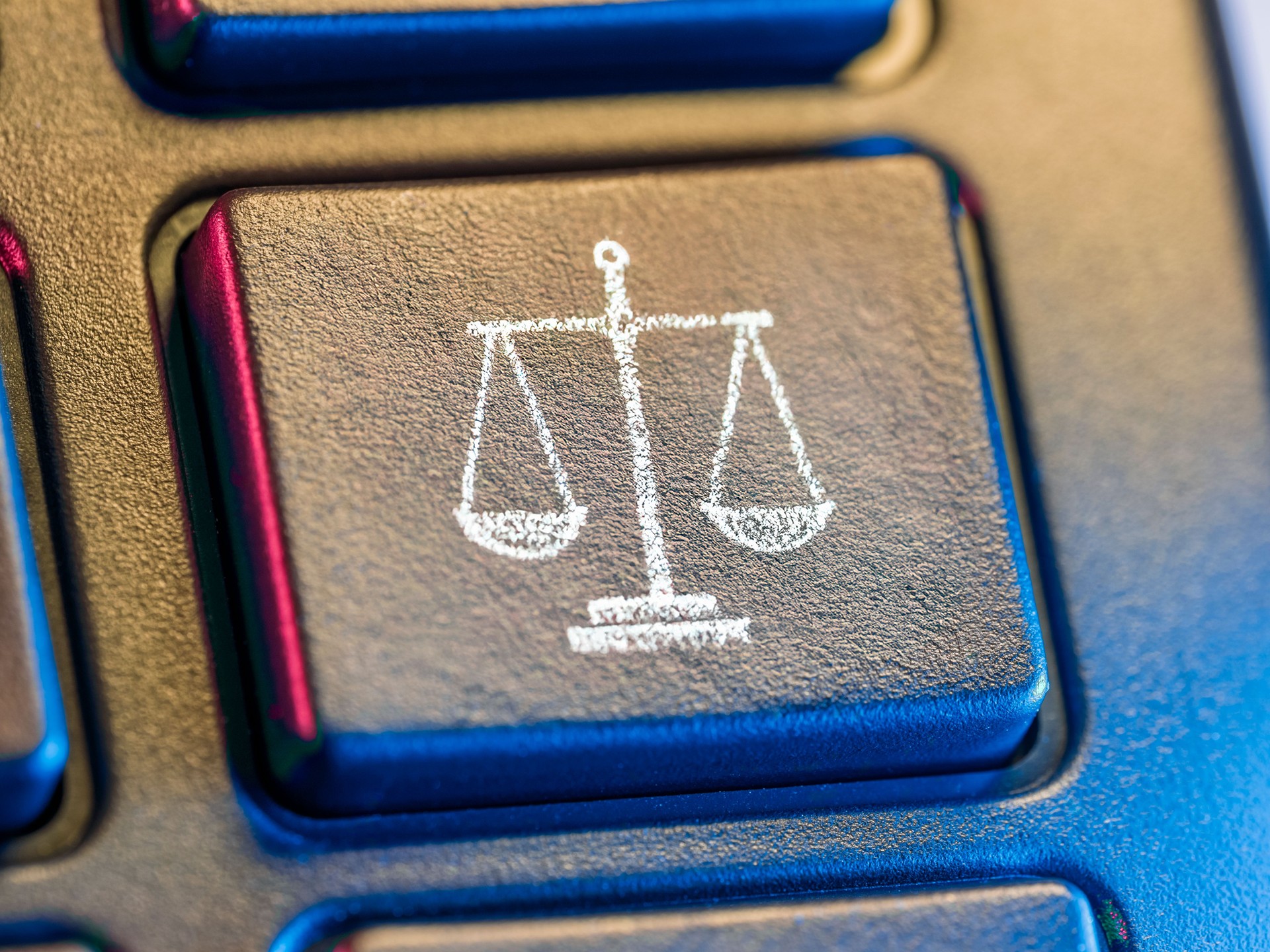 Scales drawn in chalk on a computer key as a symbol of Justice